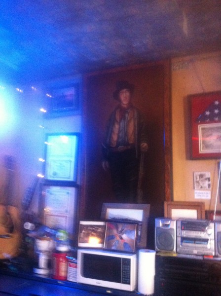 Billy the Kid looks over the bar at you in the main saloon.