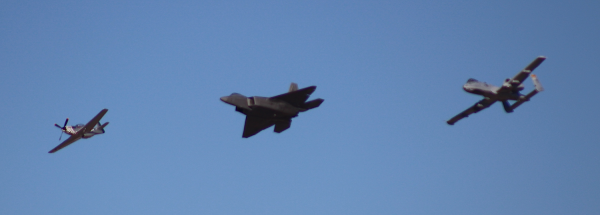 A vintage P-51 Mustang, super-modern F-22, and an A-10 Warthog fly in formation at the end of my museum visit.